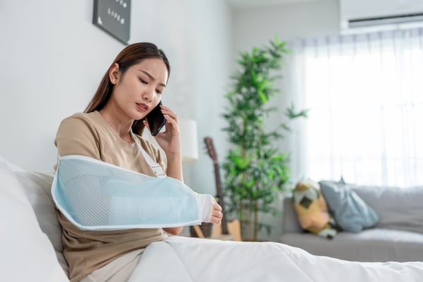 injured-asian-young-woman-talking-on-phone-in-cozy-2025-10-01-20-40-34-utc